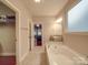 Spacious bathroom with a soaking tub, granite counters, and walk-in closet access at 105 Blossom Ridge Dr, Mooresville, NC 28117