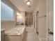 Bright bathroom with a soaking tub, walk-in shower, and granite countertops at 105 Blossom Ridge Dr, Mooresville, NC 28117