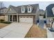 Well-manicured lawn with a two-car garage and trash receptacles along the side of the home at 105 Blossom Ridge Dr, Mooresville, NC 28117