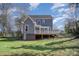Backyard view of the two story home showcasing a spacious deck and expansive yard at 116 Rose Ter, Wadesboro, NC 28170