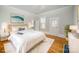 Bedroom with white bedding, wood floors, white trim, and several windows for natural light at 116 Rose Ter, Wadesboro, NC 28170