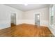 Open living room with hardwood floors, white wainscoting and trim, and large windows for natural light at 116 Rose Ter, Wadesboro, NC 28170