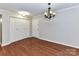 Bedroom features hardwood floors, a closet with sliding doors, and a classic chandelier at 1323 Queens Rd # 308, Charlotte, NC 28207