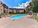 Outdoor community pool with ample seating, surrounded by lush greenery and a well-maintained lawn at 1323 Queens Rd # 308, Charlotte, NC 28207