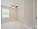 A bedroom featuring neutral carpet, ceiling fan, and a window with natural light at 1412 Meadow Ave, Kannapolis, NC 28083