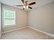 A bedroom features neutral carpet, ceiling fan, and a window for natural light at 1412 Meadow Ave, Kannapolis, NC 28083