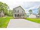 A two-story home features a gray exterior, black shutters, a welcoming front porch, and a spacious front yard at 1412 Meadow Ave, Kannapolis, NC 28083