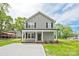Charming two-story home with a welcoming front porch, black shutters and a new concrete driveway, surrounded by lush greenery at 1412 Meadow Ave, Kannapolis, NC 28083