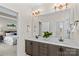 Bright bathroom with double vanity featuring marble countertops, modern lighting, and access to an adjacent bedroom at 14462 Holly Springs Dr, Huntersville, NC 28078