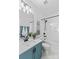 Bright bathroom with a blue vanity and shower-tub combo at 14462 Holly Springs Dr, Huntersville, NC 28078
