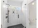 Modern bathroom featuring a glass-enclosed shower with dual showerheads, white tiled walls, and a dark tiled floor at 14462 Holly Springs Dr, Huntersville, NC 28078