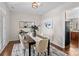 Bright dining room features modern table setting and decor, with a glimpse into the kitchen and its wood cabinets at 14462 Holly Springs Dr, Huntersville, NC 28078