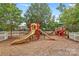 Community playground with slides, climbing structures, and soft landing surface for Gathering fun at 14462 Holly Springs Dr, Huntersville, NC 28078