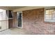Back exterior brick wall features a window and screen door leading to the enclosed porch at 1825 Hyatt Ave, Rock Hill, SC 29732