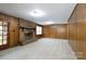 Spacious living room with a brick fireplace, wood paneling, neutral carpet, and natural light at 1825 Hyatt Ave, Rock Hill, SC 29732