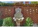 Elegant lion head fountain against a brick wall, surrounded by lush greenery creating a serene backyard focal point at 2010 Nolen Park Ln, Charlotte, NC 28209