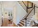 Beautiful staircase with dark wood treads, white risers and banisters and a dark handrail leading upstairs at 2010 Nolen Park Ln, Charlotte, NC 28209