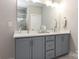 Bright bathroom with double vanity, gray cabinets, quartz counters and a glass enclosed shower at 2014 Bryant Park Dr, Charlotte, NC 28208
