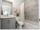 Clean bathroom featuring gray cabinetry, a quartz countertop, and a shower-tub combination with marble tiling at 2014 Bryant Park Dr, Charlotte, NC 28208