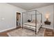 Bright bedroom with a four-poster bed, hardwood floors, and a view into an adjoining bathroom at 2014 Bryant Park Dr, Charlotte, NC 28208