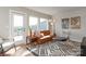 Inviting living room featuring a leather couch, a bar cart, and natural light from windows and a door to the balcony at 2014 Bryant Park Dr, Charlotte, NC 28208