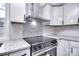 Up close view of a range and backsplash in a kitchen with granite countertops at 2147 Stanley Dr, Lincolnton, NC 28092