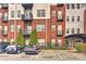 Exterior view of a red brick building with metal accents, multiple balconies, and well-defined parking spaces at 2338 Yadkin Ave # 205, Charlotte, NC 28205