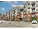 Exterior view of a multi-story building with red brick and metal accents, showcasing multiple balconies and parking at 2338 Yadkin Ave # 205, Charlotte, NC 28205
