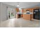 Bright kitchen with wood cabinets, black appliances, and a sliding door to patio at 2349 Gooseberry Rd, Charlotte, NC 28208