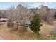 Aerial view of the property with a green roofed house, weathered outbuildings, and trees surrounding the home at 2845 Wood Gate Rd, Lincolnton, NC 28092