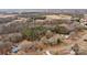 Wide aerial view of a property featuring a home with a green roof, outbuildings, and tree-lined boundaries at 2845 Wood Gate Rd, Lincolnton, NC 28092