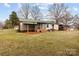 View of the home's backyard featuring a lawn, small storage shed, and a covered porch area at 2845 Wood Gate Rd, Lincolnton, NC 28092