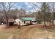 Exterior view of a home with a green roof, weathered outbuildings, and a spacious yard with mature trees at 2845 Wood Gate Rd, Lincolnton, NC 28092