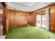 Living room featuring wood paneling, vintage light fixtures, and sliding glass doors to a sunroom at 2845 Wood Gate Rd, Lincolnton, NC 28092