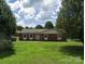 Charming single-story brick home with a well-maintained lawn and mature trees creating a peaceful and inviting curb appeal at 3003 Winston Nw Dr, Concord, NC 28027