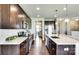 This modern kitchen features dark wood cabinetry, an island with seating, and stainless steel appliances at 3542 Rapport Ct # 37, Lancaster, SC 29720