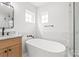 Modern bathroom featuring a stand alone tub and marble tile walls at 3646 46Th Ne Ave, Hickory, NC 28601