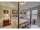 Cozy bedroom featuring a four-poster bed, bedside table, and natural light from the window at 5002 Stonehill Ln, Matthews, NC 28104