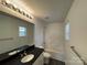 Bathroom features a black countertop, large mirror, and a shower-tub combination at 514 Meadowrock Dr, Albemarle, NC 28001