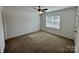 Cozy bedroom featuring neutral walls, carpet flooring, a ceiling fan and a bright window at 514 Meadowrock Dr, Albemarle, NC 28001