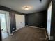 The carpeted bedroom features a dark color palette, closet, and natural light from the window at 514 Meadowrock Dr, Albemarle, NC 28001
