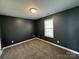 The carpeted bedroom features a dark color palette and natural light from the window at 514 Meadowrock Dr, Albemarle, NC 28001