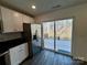 Well-lit kitchen with stainless steel appliances, white cabinets, dark countertops, and a sliding glass door to a deck at 514 Meadowrock Dr, Albemarle, NC 28001