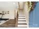 Welcoming entryway with elegant staircase, hard wood floors, and a view into an exercise room at 613 Tudor Park Way, Charlotte, NC 28211