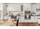 Stylish kitchen featuring white cabinets, stainless steel appliances, and dining area with hardwood floors at 613 Tudor Park Way, Charlotte, NC 28211