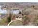 Breathtaking aerial shot featuring a beautiful home surrounded by a pond and a lush tree line at 706 Eagle Point Ct, Weddington, NC 28104