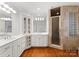 Elegant bathroom with tiled shower, white cabinets, double sinks, and modern lighting at 706 Eagle Point Ct, Weddington, NC 28104