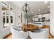 Bright dining area with modern chandelier, large windows, and views into a white kitchen at 706 Eagle Point Ct, Weddington, NC 28104