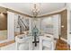 Elegant dining room features a glass table, designer chairs, stylish chandelier, and decorative columns at 706 Eagle Point Ct, Weddington, NC 28104