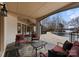 Covered stone patio area with lounge seating overlooking the pool and lake at 706 Eagle Point Ct, Weddington, NC 28104